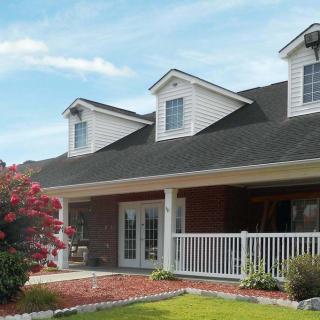 A residential house with a spacious porch and well-maintained garden.