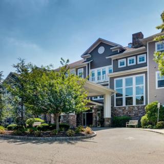 A large residential building surrounded by trees and landscaping.