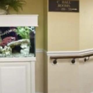 A hallway interior featuring an aquarium and a handrail.