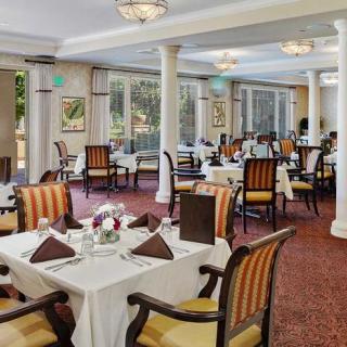 An elegant dining room with neatly set tables and comfortable chairs, ready for guests.