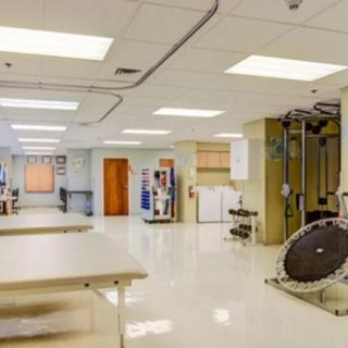 A clean and well-organized laboratory interior with medical equipment and tables, illuminated by ceiling lights.