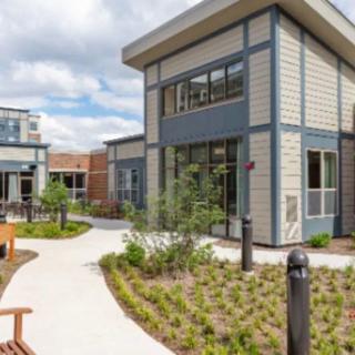 A modern building complex with landscaped pathways and greenery.
