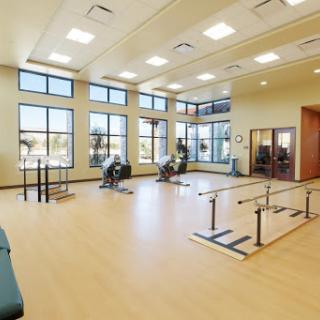 A bright and spacious physical therapy room equipped for rehabilitation exercises.