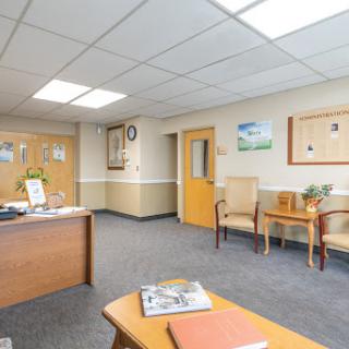 A welcoming office waiting area with a reception desk and comfortable seating.