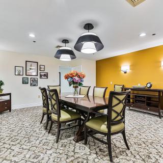 A stylish dining room with a wooden table, cushioned chairs, and elegant lighting.