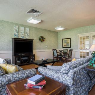 A cozy living room with patterned sofas, a television, and a wooden coffee table.