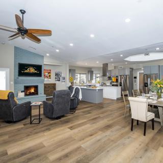 A spacious open-concept living area featuring a modern kitchen, dining space, and cozy living room with a fireplace.