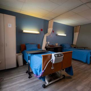 A hospital room with two patient beds and medical equipment.