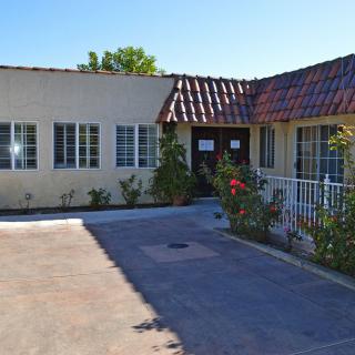 A single-story residential house with a driveway and garden.