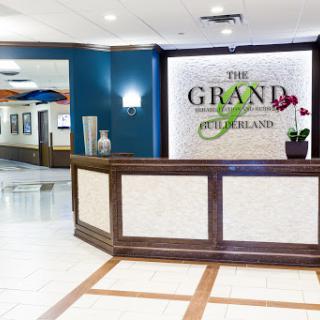 The elegant reception area of The Grand Hotel, featuring a stylish wooden counter and modern decor.