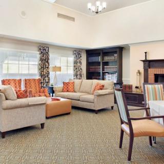 A cozy living room with sofas, a fireplace, and large windows.
