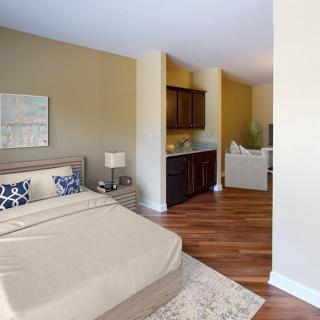 A modern bedroom featuring a comfortable bed, elegant decor, and hardwood flooring.