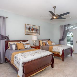 A well-decorated bedroom with two beds, a ceiling fan, and elegant decor.