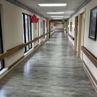 An empty hallway in a building with handrails and decorations on the walls.