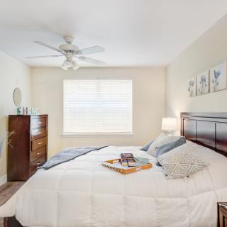 A cozy bedroom with neutral tones featuring a neatly made bed and elegant decor.