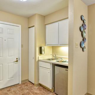 A compact kitchen area with white cabinets, a sink, and a dishwasher.