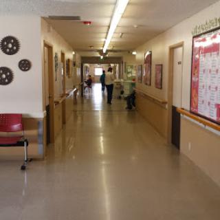 A quiet hallway in a healthcare facility with doors leading to various rooms.