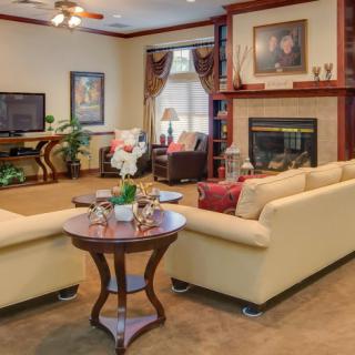 A cozy living room with comfortable beige sofas, a fireplace, and a television creating a warm, inviting atmosphere.