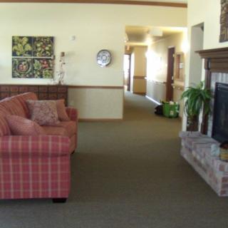 A cozy living room area featuring a patterned couch, a fireplace, and decorative artwork on the walls.