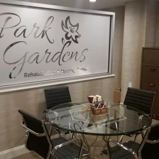 A modern office meeting room with a glass table and comfortable chairs.