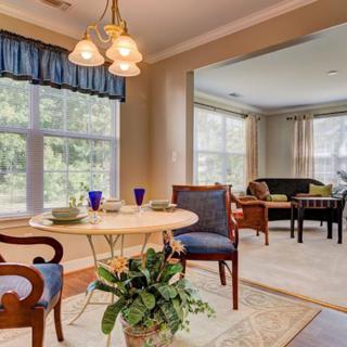 A cozy dining and living area with elegant furniture and abundant natural light.