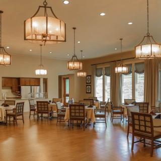 A spacious dining area with elegant lighting and large windows.