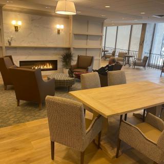 A cozy living room with modern furnishings, featuring a fireplace and comfortable seating.