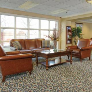 A comfortable lobby area with leather furniture and large windows providing natural light.