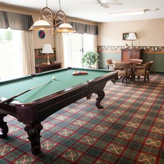 A well-furnished recreation room featuring a billiards table and cozy seating area.