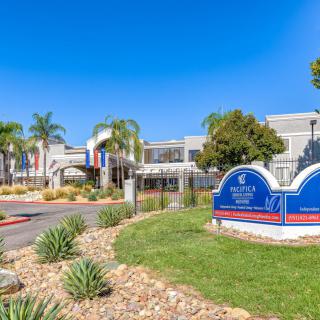 A healthcare facility with landscaped surroundings and clear blue skies.