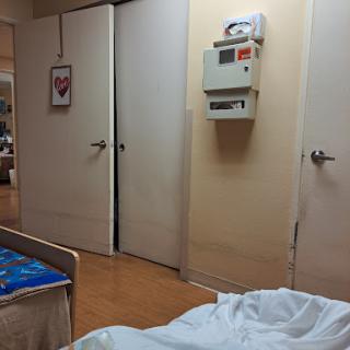 A view of a hospital room featuring a bed and closed doors.