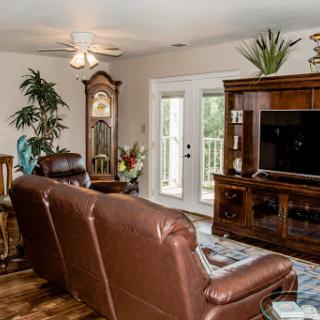 A cozy living room featuring leather seating, a wooden entertainment center, and decorative elements.