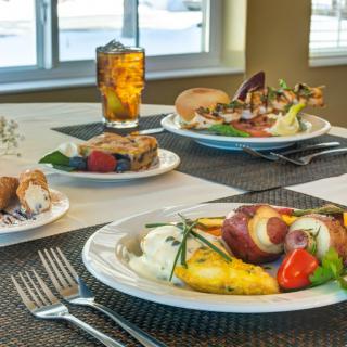 A beautifully set table with a variety of plated dishes and a drink, ready for dining.