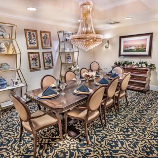 Elegant dining room with a large table, ornate chandelier, and tasteful decor.