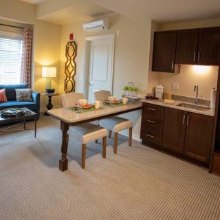 A cozy living room with a kitchenette, featuring a comfortable seating area and modern decor.