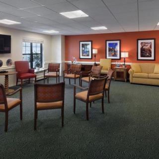 An inviting waiting room with a circle of chairs, warm lighting, and colorful artwork on the walls.