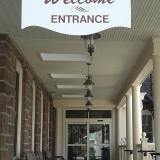 Entrance to a building with a welcome sign above the porch.