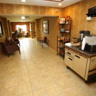 A hotel lobby with a coffee station and seating area.