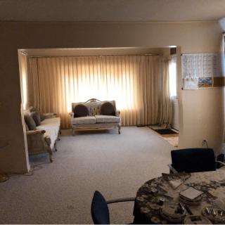 A cozy living room with sofas and a table set against a backdrop of curtains.