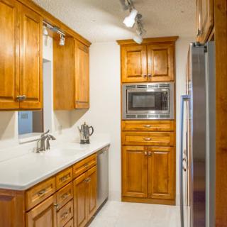 A modern kitchen featuring warm wooden cabinets and sleek appliances.