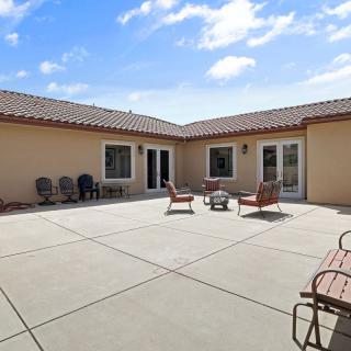 Spacious outdoor patio area with seating and a sunny sky.