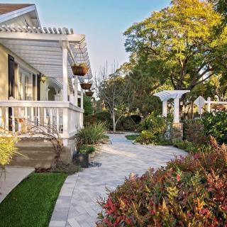 A charming house with a beautifully landscaped garden and pathway.