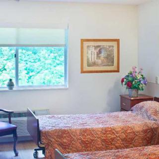 A cozy bedroom with twin beds and a decorative flower arrangement.