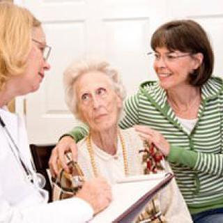 A doctor consults with an elderly woman and her caregiver.