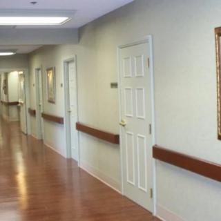 A clean and well-lit hospital corridor with doors along the sides.