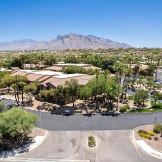 An aerial view of a suburban neighborhood with a backdrop of mountains and lush greenery.