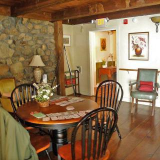 A cozy dining room with wooden furniture and a rustic stone wall.