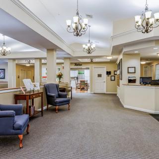 A spacious and well-lit lobby area featuring comfortable seating and a reception desk.