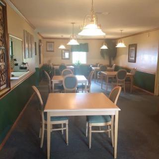 An empty dining room with neatly arranged tables and chairs.