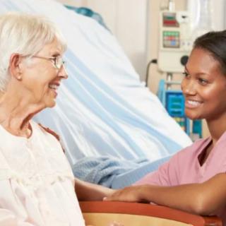A nurse engaging with an elderly patient in a healthcare setting.